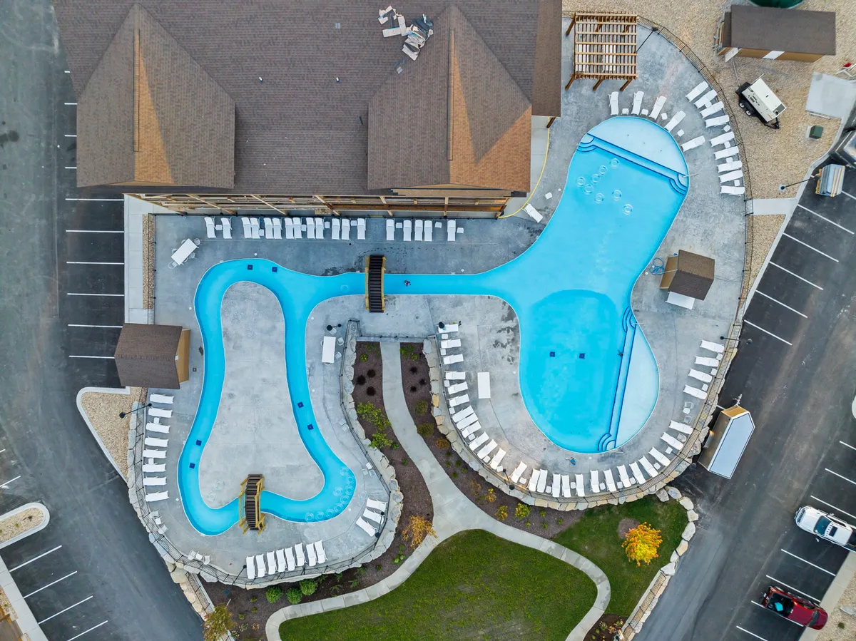 This image captures the resort's outdoor pool area with sparkling swimming pools, inviting lounge chairs, and lush landscaped surroundings, evoking a lively, social atmosphere perfect for summer fun and relaxation.