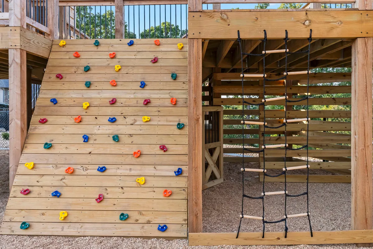 This energetic exterior shot features a climbing wall and rope ladder, capturing children actively climbing and exploring. The setting encourages creative play and team challenges, making it an ideal representation of family-friendly fun and adventure experiences available on the property.