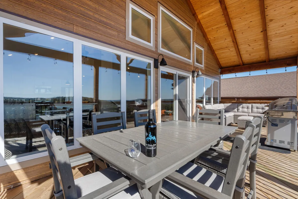 An exterior scene showcasing an outdoor dining table set for a meal, with seating arranged to enjoy expansive views of the surrounding landscape and a bottle of wine on the table, hinting at leisurely moments after a day of exploring.